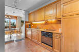 Discover this charming kitchen with warm wooden cabinetry and a modern cooktop.
