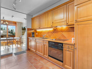 Discover this charming kitchen with warm wooden cabinetry and a modern cooktop.