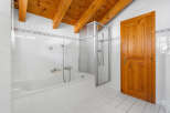 This charming bathroom features a classic design with a wooden ceiling and a bright, airy feel.