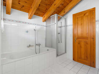 This charming bathroom features a classic design with a wooden ceiling and a bright, airy feel.