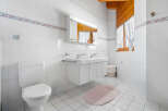 This bright and airy bathroom features a clean, modern design with white tile walls and flooring.