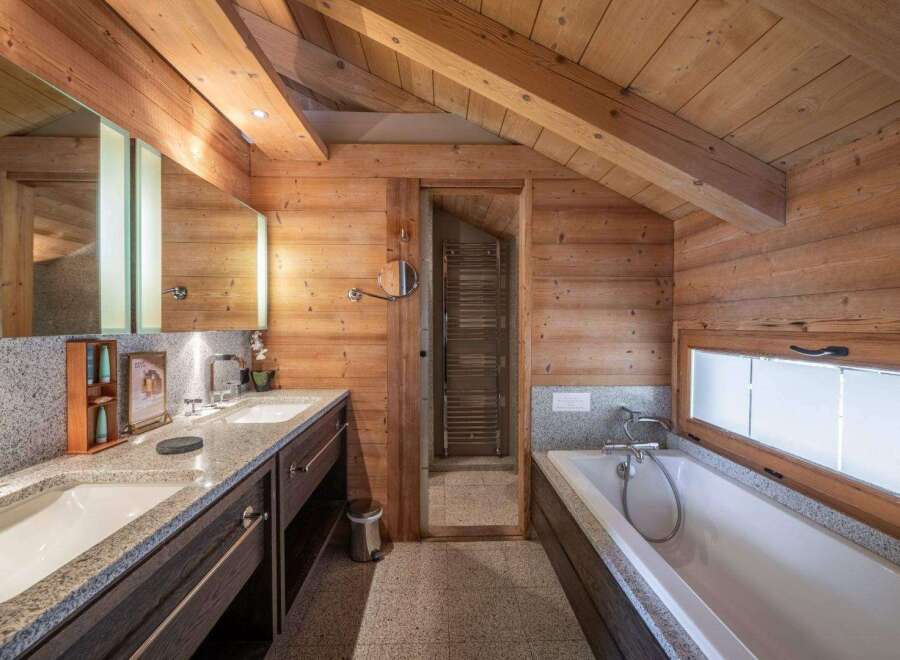 This stunning bathroom features a rustic design with wooden walls and ceiling, creating a warm and inviting atmosphere.