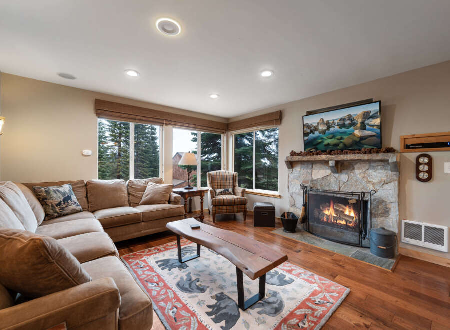 Step into cozy luxury with this stunning living room! Featuring a stone fireplace, hardwood floors, and a comfortable sectional sofa, it's the perfect space for relaxation and entertaining.