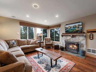 Step into cozy luxury with this stunning living room! Featuring a stone fireplace, hardwood floors, and a comfortable sectional sofa, it's the perfect space for relaxation and entertaining.