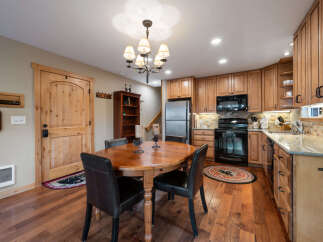 This charming kitchen features warm wood cabinetry, a stainless steel refrigerator, and a black oven and microwave.