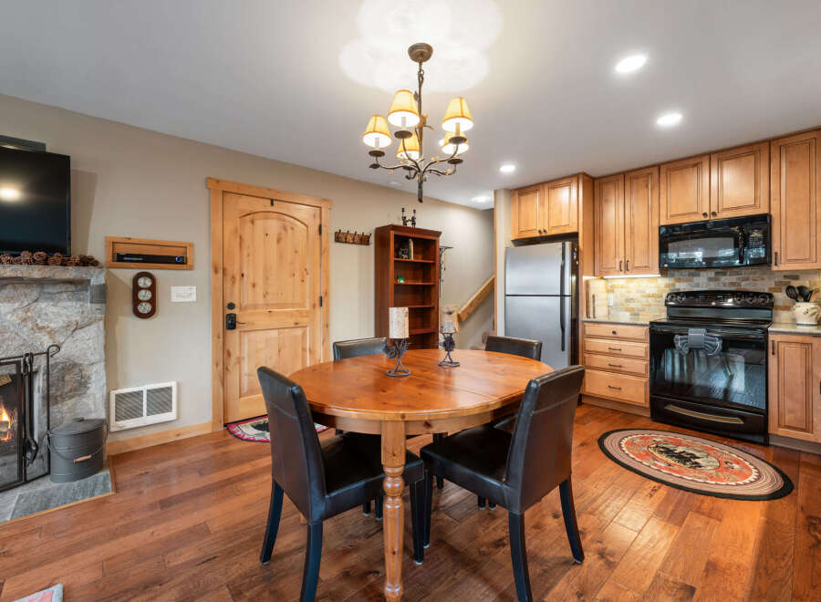 This charming property features a cozy dining area with a rustic wooden table and comfortable seating, perfect for intimate gatherings.
