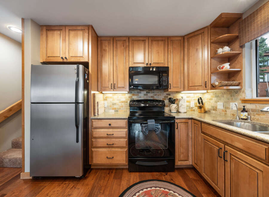 This stunning kitchen boasts beautiful wooden cabinetry and modern appliances, creating a warm and inviting atmosphere.