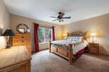 This cozy bedroom features a rustic wooden bed frame, complemented by matching nightstands and a dresser, creating a warm and inviting atmosphere.