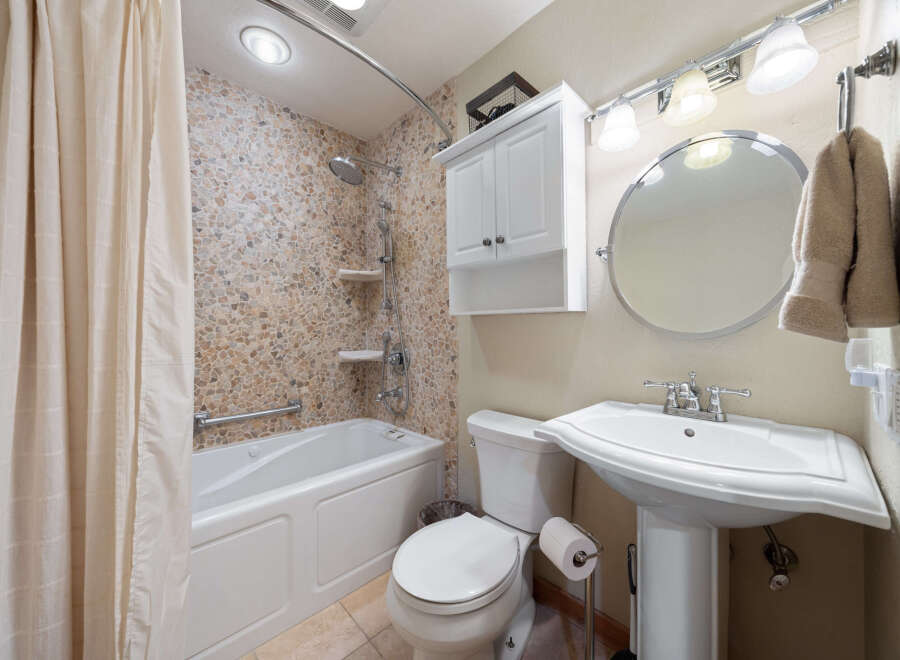 This charming bathroom features a stylish combination of functionality and design.