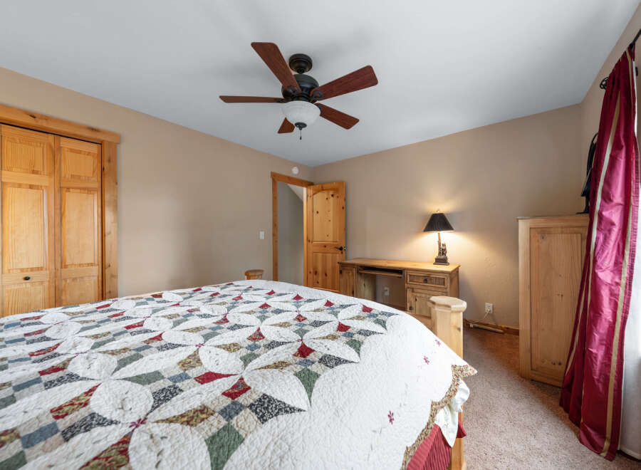 This cozy bedroom features a charming quilt-covered bed, perfect for a relaxing retreat.