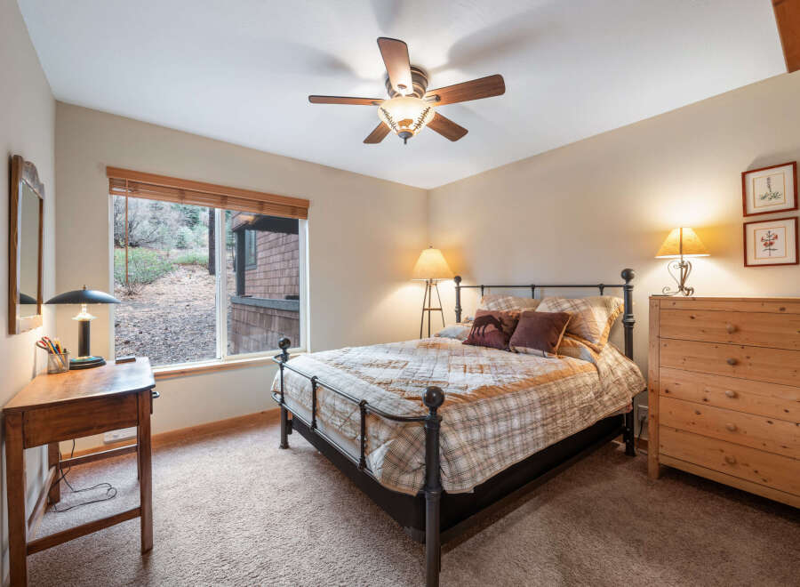 This cozy bedroom features a comfortable bed with a stylish quilt and decorative pillows, perfect for a relaxing retreat.