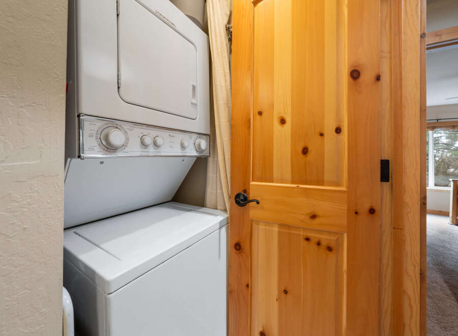 This stunning property boasts a convenient laundry area, featuring a modern stacked washer and dryer.