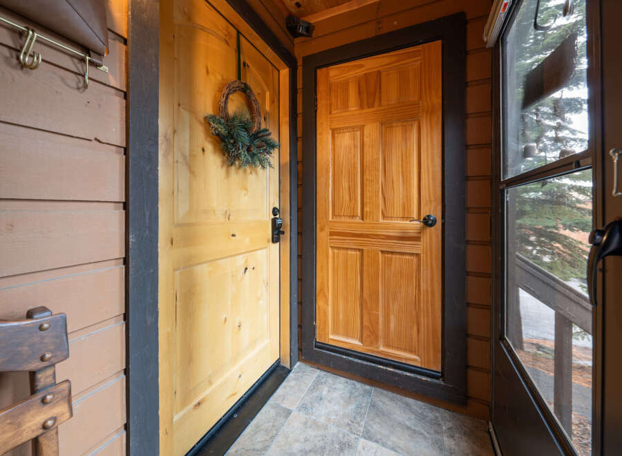 Step into a welcoming entryway with a charming wooden door adorned with a festive wreath.