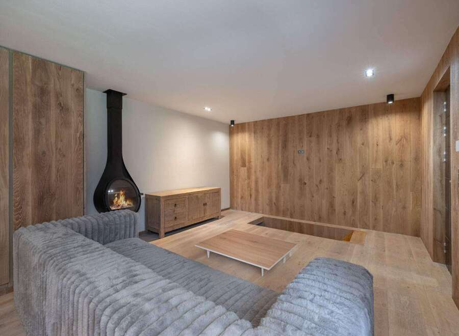 This stunning living space boasts a modern fireplace, creating a warm and inviting atmosphere.