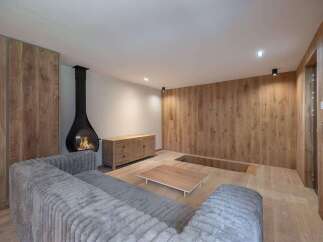 This stunning living space boasts a modern fireplace, creating a warm and inviting atmosphere.
