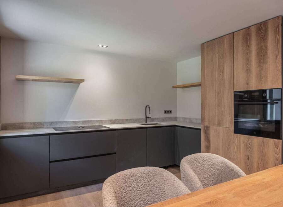 This modern kitchen boasts sleek, dark cabinetry and a stylish countertop, perfect for culinary enthusiasts.