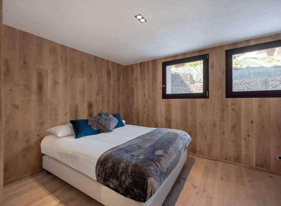 This cozy bedroom features stunning wood paneling that adds warmth and character to the space.