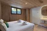 This stunning bedroom features a warm, inviting atmosphere with its wood-paneled walls and ceiling.