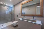 This modern bathroom features a sleek design with a spacious shower and a stylish vanity.