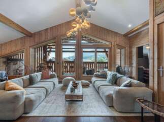 Experience luxury living in this stunning chalet, featuring a spacious living area with a cozy fireplace and breathtaking mountain views.