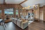 Experience luxury living in this stunning property, featuring a spacious living room with a cozy fireplace and large windows offering breathtaking views.