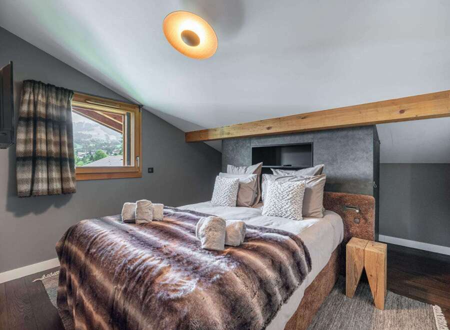 Experience luxury in this stunning bedroom featuring a cozy bed with a faux fur blanket.