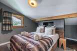 Experience luxury in this stunning bedroom featuring a cozy bed with a faux fur blanket.