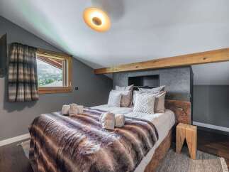 Experience luxury in this stunning bedroom featuring a cozy bed with a faux fur blanket.