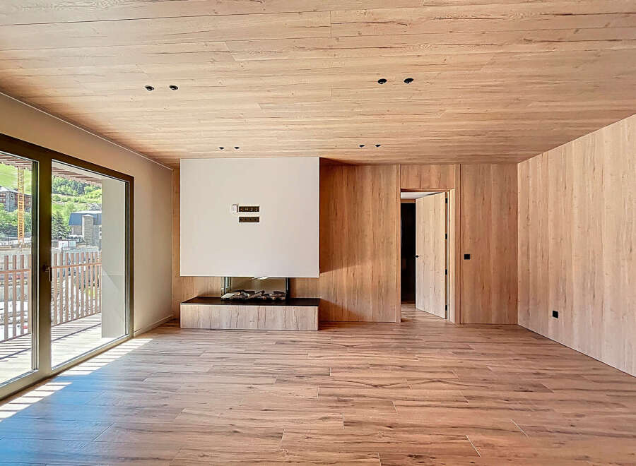 Experience luxury living in this stunning property featuring a modern fireplace and elegant wooden accents throughout.