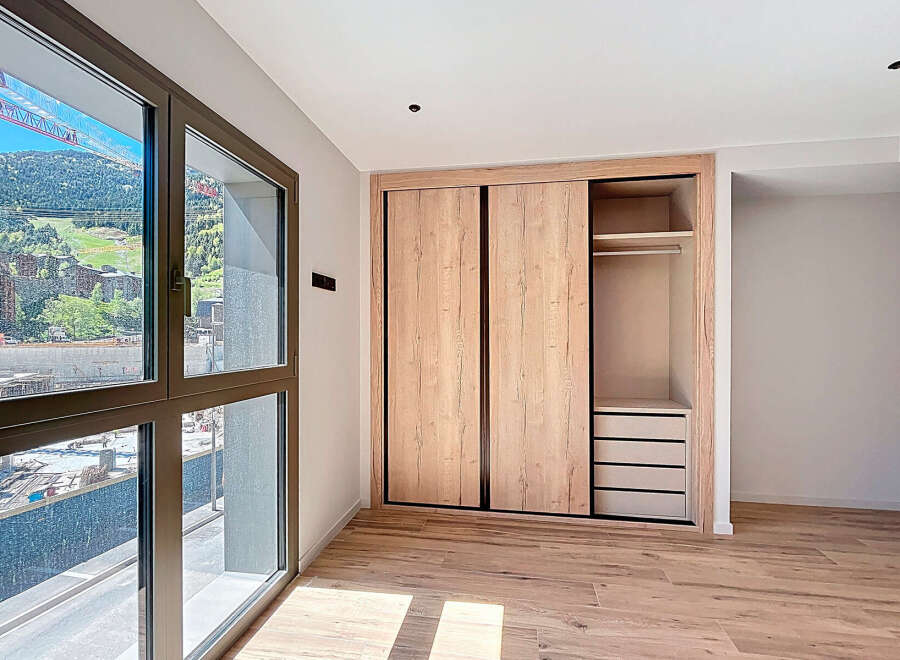 Discover the elegance of this modern bedroom, featuring a spacious built-in wardrobe with sliding doors, offering ample storage.