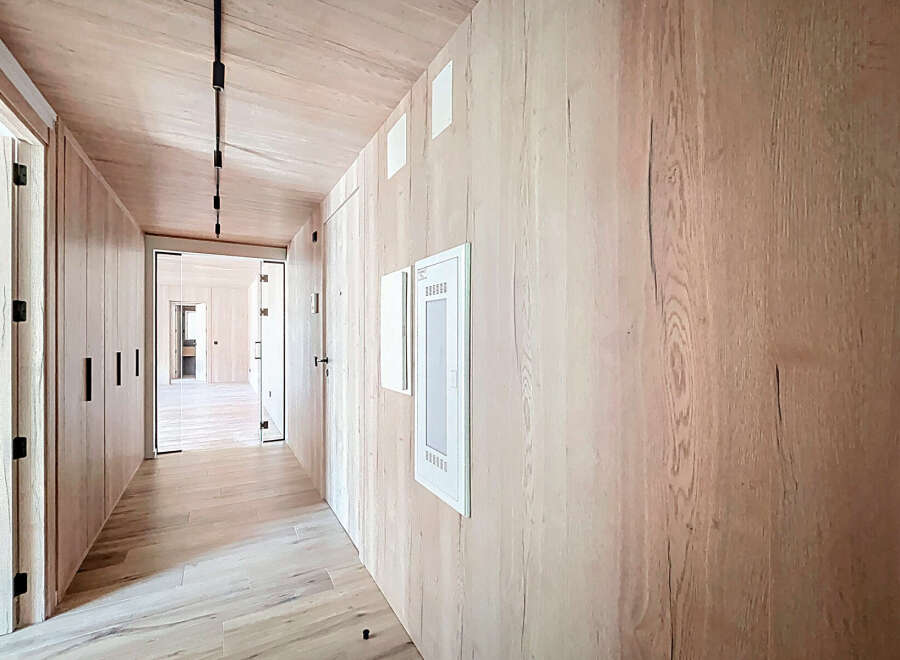 Step into luxury with this stunning hallway, showcasing exquisite wood paneling and a modern design.