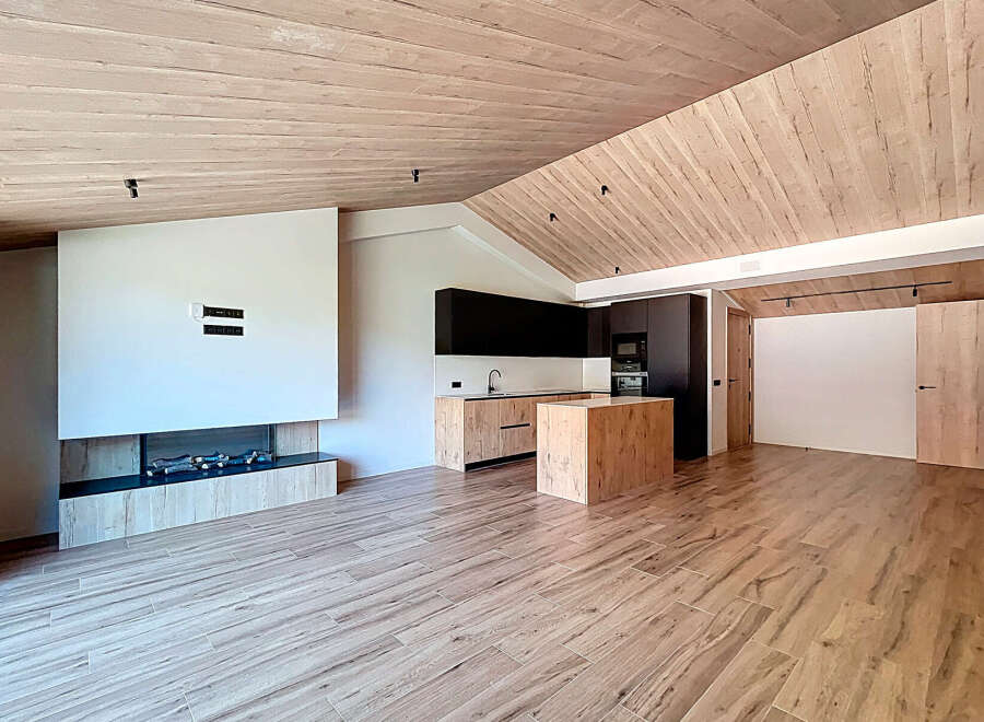 This stunning modern home features a spacious open-concept design with a beautiful kitchen and a cozy fireplace.