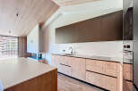 This modern kitchen boasts a sleek design with wooden cabinetry and a minimalist aesthetic.