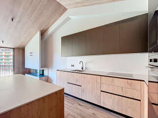This modern kitchen boasts a sleek design with wooden cabinetry and a minimalist aesthetic.