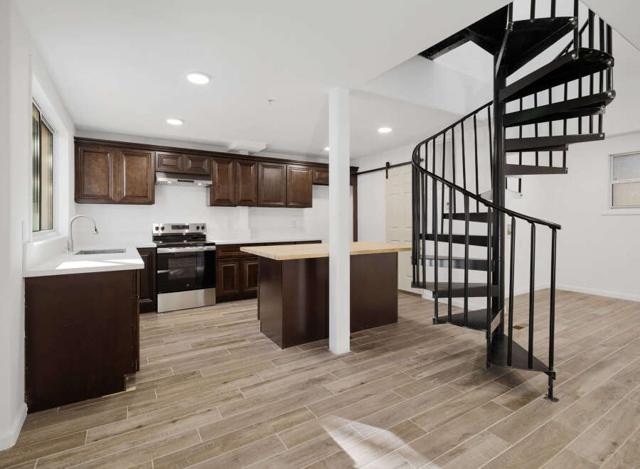 This stunning kitchen boasts dark wood cabinetry, stainless steel appliances, and a spacious island with a butcher block countertop.
