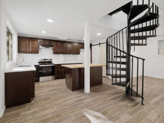 This stunning kitchen boasts dark wood cabinetry, stainless steel appliances, and a spacious island with a butcher block countertop.