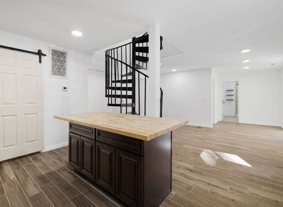 This stunning property features a modern kitchen with a stylish island and a beautiful wooden countertop.