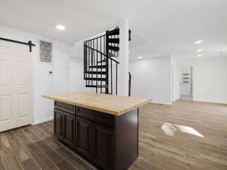 This stunning property features a modern kitchen with a stylish island and a beautiful wooden countertop.