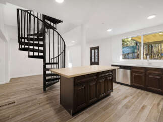This stunning property features a modern kitchen with a large island and stainless steel appliances.