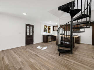 This stunning property boasts a modern interior with a striking spiral staircase as its centerpiece.