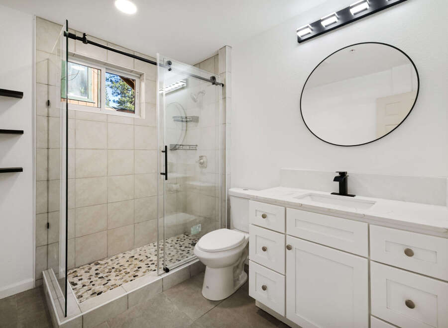Step into a beautifully designed bathroom featuring a modern glass shower and a stylish vanity.