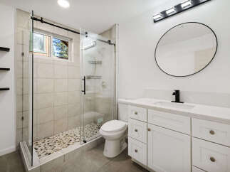 Step into a beautifully designed bathroom featuring a modern glass shower and a stylish vanity.