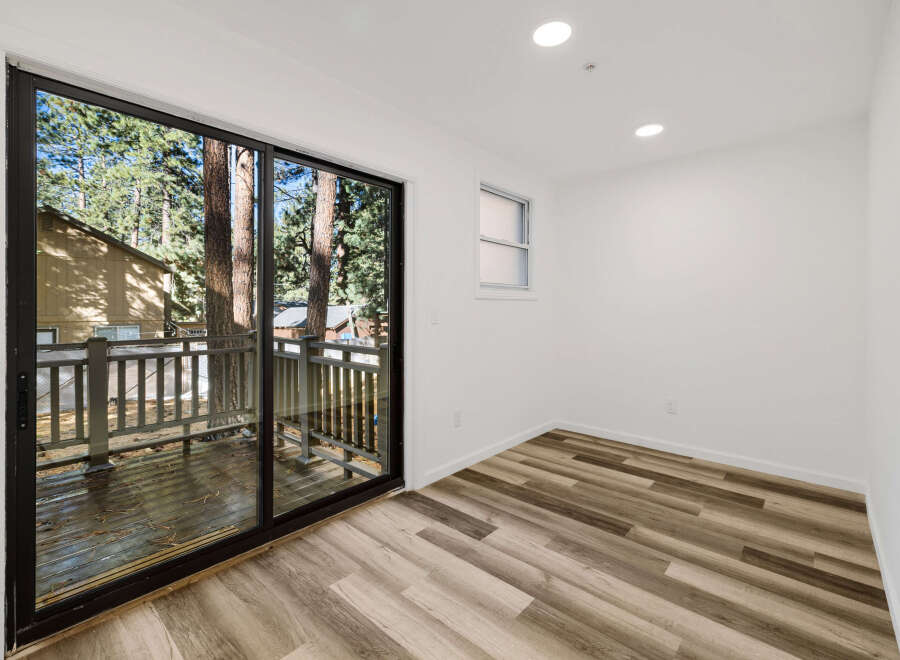 Step into this bright and airy room, featuring a stunning view through a large sliding glass door.