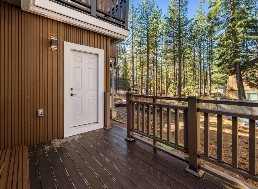 Enjoy the tranquility of this stunning property with a beautiful wooden deck and a charming white door.