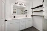 This stunning bathroom boasts a modern design with sleek white cabinetry and a pristine countertop.