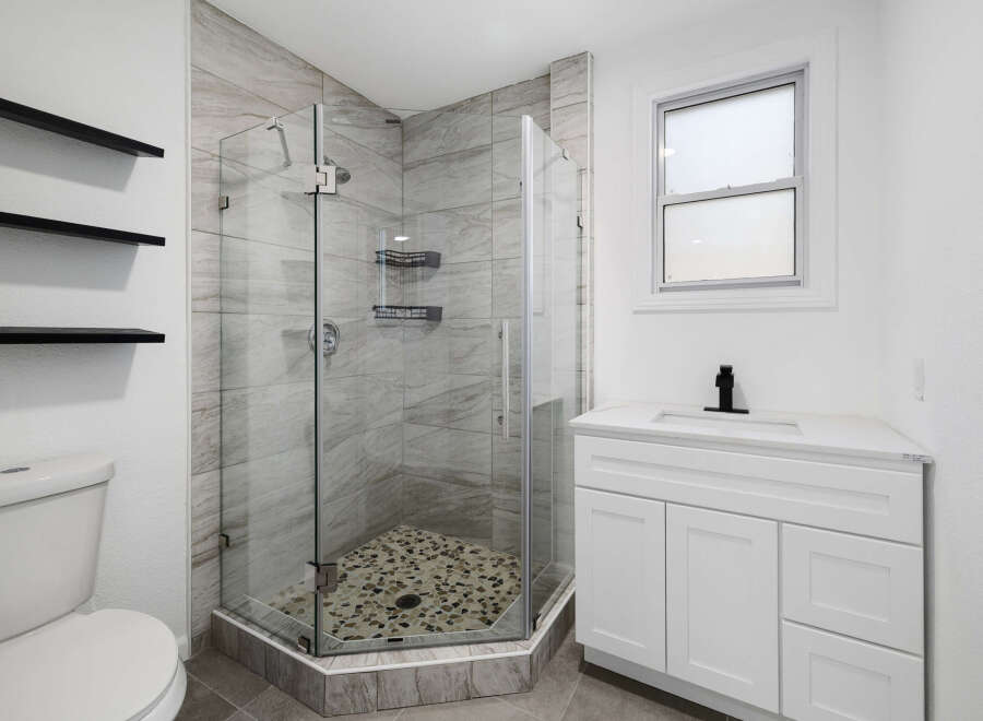 Step into a modern bathroom oasis! This stunning space features a sleek glass-enclosed shower with stylish tile, offering a spa-like experience.