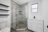 Step into a modern bathroom oasis! This stunning space features a sleek glass-enclosed shower with stylish tile, offering a spa-like experience.
