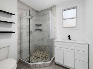 Step into a modern bathroom oasis! This stunning space features a sleek glass-enclosed shower with stylish tile, offering a spa-like experience.
