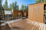 This stunning property boasts a modern design with beautiful wood siding and a spacious deck, perfect for enjoying the outdoors.