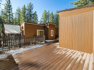 This stunning property boasts a modern design with beautiful wood siding and a spacious deck, perfect for enjoying the outdoors.